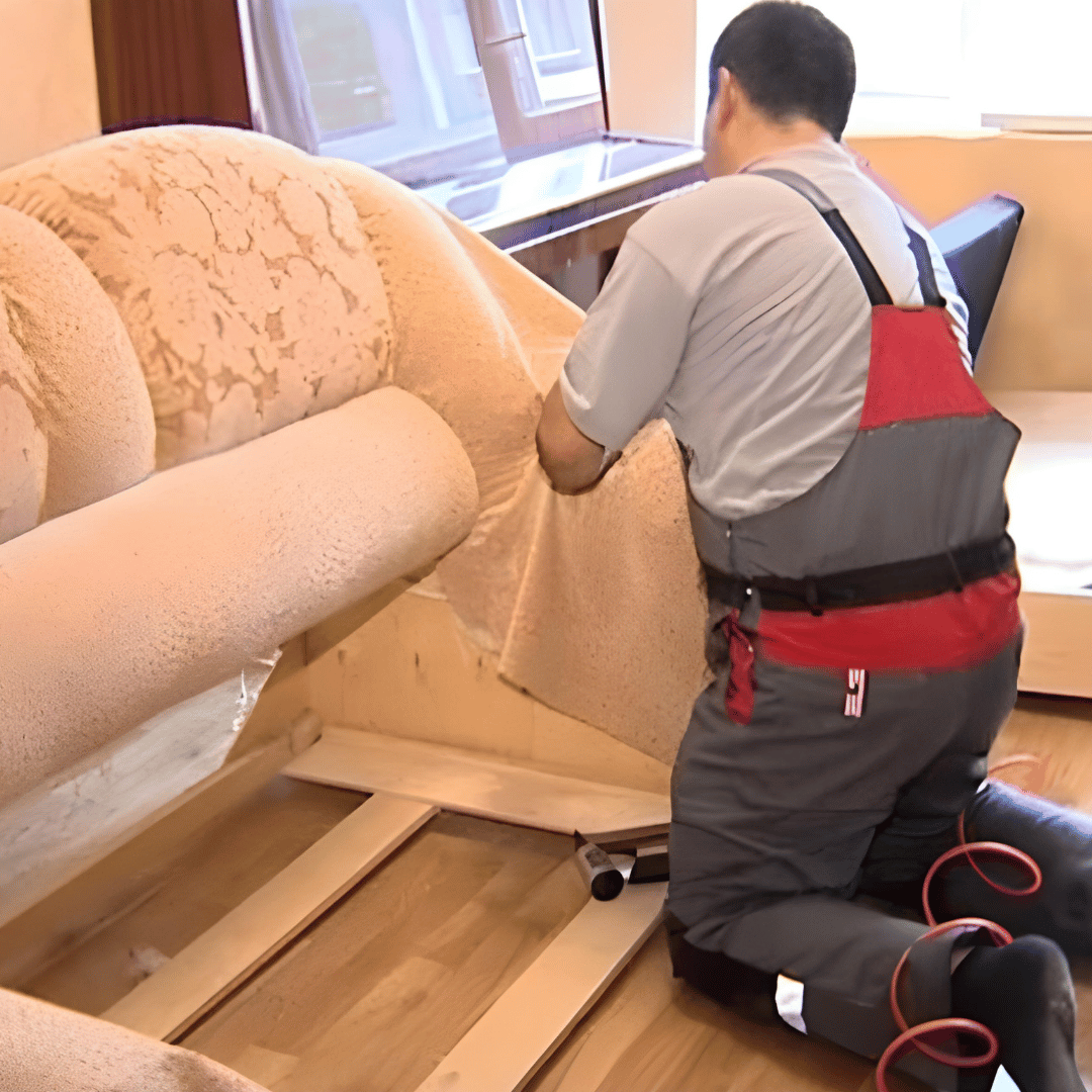 Close-up of a craftsman repairing a wooden sofa frame.